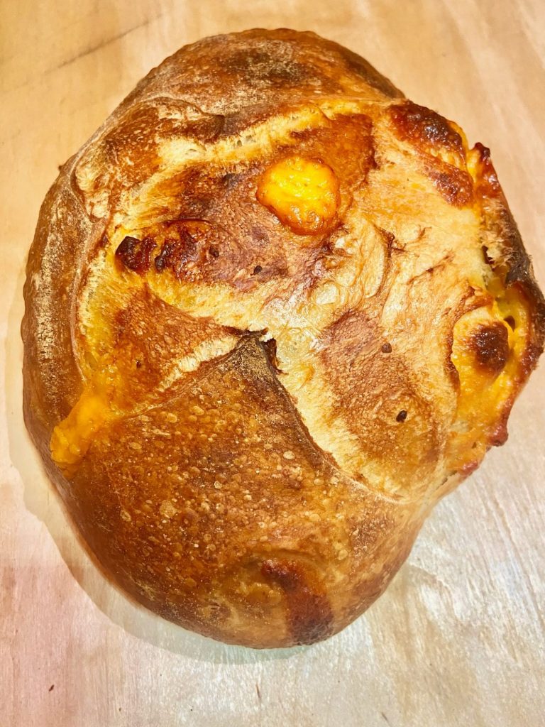 Picture of a light brown loaf infused with evaporated belgian-style wheat ale and cheddar cheese